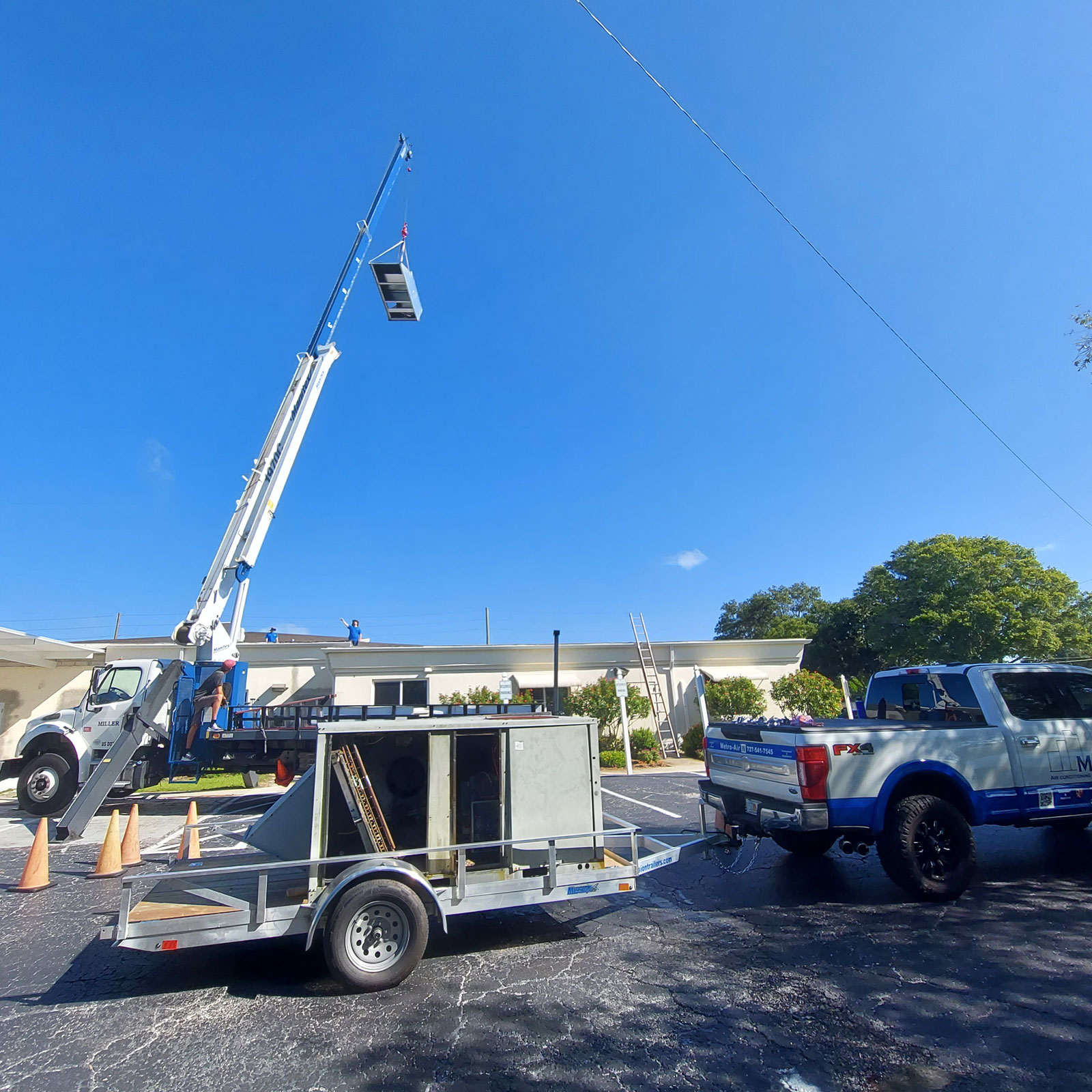 Old rooftop unit being removed by crane before replacement